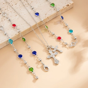 Dettaglio della collana d'argento con pietre colorate e ciondolo a croce su pietra