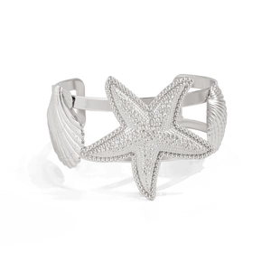 Makrodetail der silbernen Seestern- und Muscheltexturen auf dem Manschettenarmband