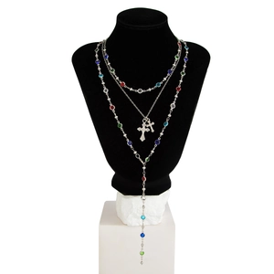 Dettaglio di una collana d'argento a più strati con gemme colorate e croci