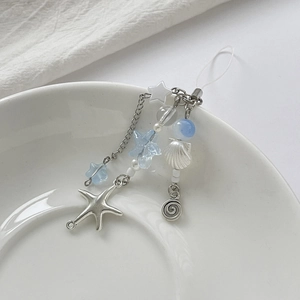 Detail of marine-style phone strap with metal starfish, shell charms and blue beads