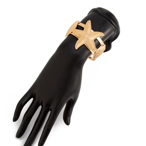 Detail eines goldenen Seestern- und Muschelarmbands mit strukturierter Meeresoptik