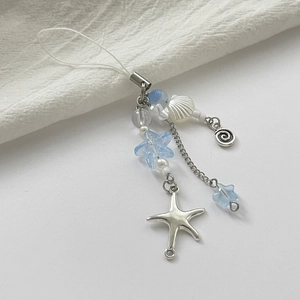 Detail of starfish and shell charms on a blue ocean theme keychain for handbags
