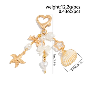 Detail view of shell and starfish keychain with measurements showing 9cm total length