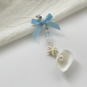 Detail of blue ribbon bow phone charm with pearl shell and starfish beads