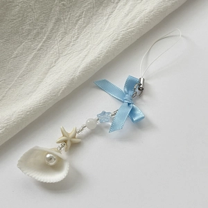 Detailed shot of ocean-style keychain with blue bow, seashell charm and starfish bead