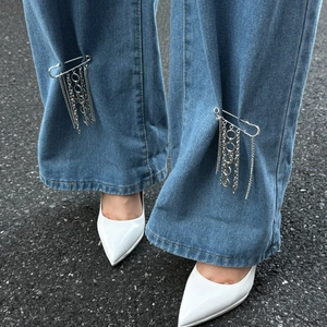 Punk-Stil Silberstern Quastenkette Pin-Accessoire an Jeans mit weißen Stiefeln getragen
