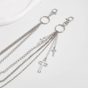 Detailed view of layered silver metal hip-hop waist chain with cross pendants