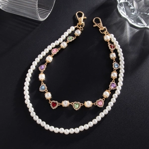 Close-up of layered punk waist chain featuring colorful rhinestone hearts and white faux pearls