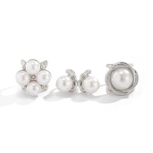 Detailed view of silver rings featuring white pearls in floral and bow-knot designs