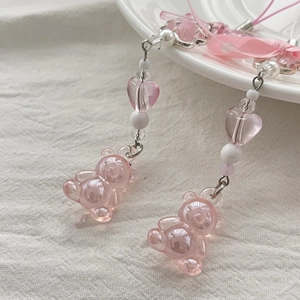 Detail of pink resin bear charms with beaded heart chain and silk bow accessories