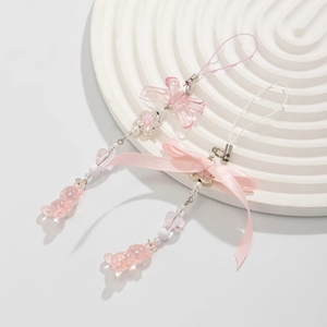 Detail of pink Y2K beaded phone charms with acrylic bears and silk ribbon bows
