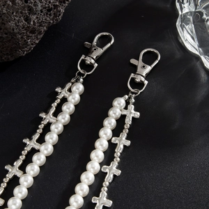 Détail de la chaîne de pantalon avec perles blanches et pendentifs croix punk