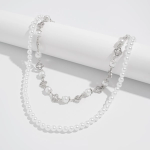 Close-up of double-layer faux pearl pant chain with silver clover charms and rhinestones