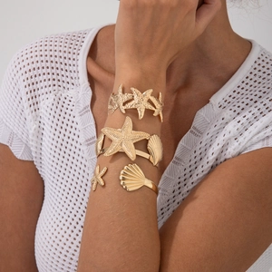 Drei goldene Armreifen im Ozean-Stil mit Seestern und Muschelrelief für den Strand-Look