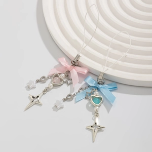 Detail of pink and blue ribbon bow phone charms with heart beads on white tray