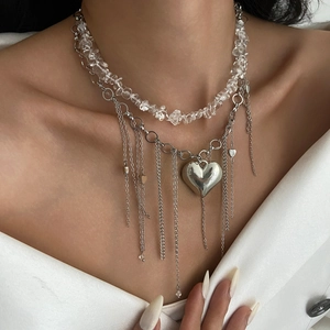 Dettaglio collana a strati con perle di cristallo e ciondolo a cuore grande