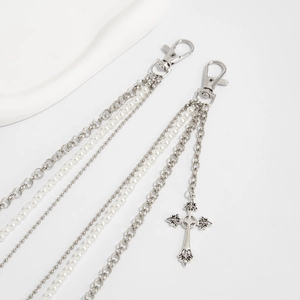 Détail d'une chaîne de pantalon punk multicouche avec perles et pendentifs croix