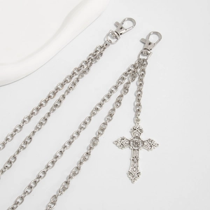 Detail of silver gothic waist chain featuring a carved cross pendant and lobster clasps