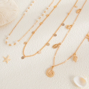 Detail view of 4-piece gold beach waist chains with sea shells, pearls and sequins