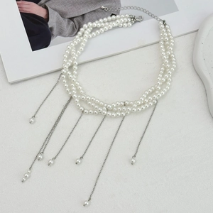 Dettaglio della collana di perle a tre fili con eleganti nappe in metallo argento