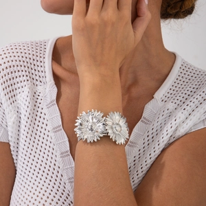 Detail van zilveren zonnebloem armmanchet met verfijnde bloemblaadjes op een open ring