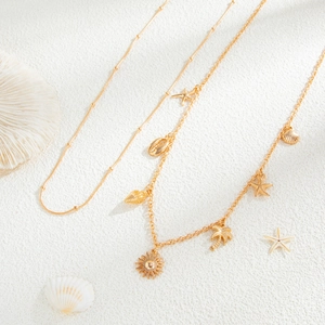 Detail of gold beach waist chain with starfish, seashell, and coconut tree charms