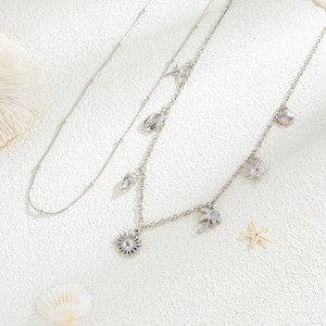 Detail of double-layered silver waist chain with starfish, shell, and palm tree charms