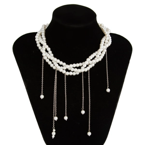 Dettaglio della collana di perle multistrato con nappe in metallo argento su busto