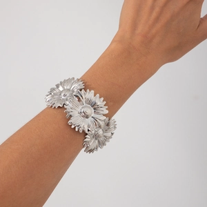Gedetailleerd overzicht van de zilveren zonnebloem armband met drie 3D-madeliefjes