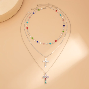 Dettaglio di collana a Y a tre strati con cristalli colorati e ciondoli a croce