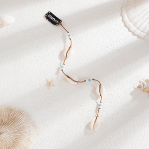 Détail d'accessoire de cheveux bohème avec coquillages blancs naturels et perles sur cordon