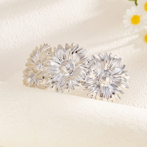 Detailweergave van zilveren zonnebloem armband met fijne bloembladtextuur op wit