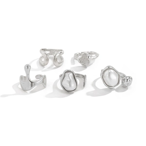 Detail of five liquid metal silver rings featuring baroque pearls in a minimalist set