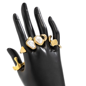 Detailed shot of baroque pearls on gold irregular rings and geometric cuff bracelet