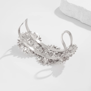 Detailopname van de zilveren zonnebloem armband met getextureerde bloembladen en glans
