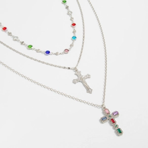 Dettaglio macro della collana a tre strati d'argento con gemme colorate e croci
