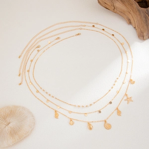 Detail of gold beach body chain featuring starfish shells and imitation pearls