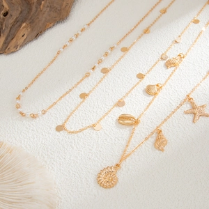 Detailed macro of gold-tone multi-layer waist chain with starfish shells and pearls