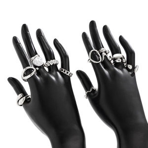 Detail shot of irregular silver metal rings with pearls on black hand models