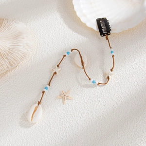 Détail d'accessoire de cheveux bohème avec coquillages naturels et perles pour la plage