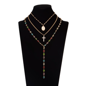 Dettaglio di collana a tre strati dorata a Y con icone religiose e gemme multicolore