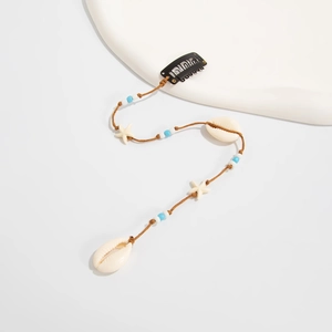 Détail de pince à cheveux avec coquillages, étoiles de mer et perles sur cordon brun