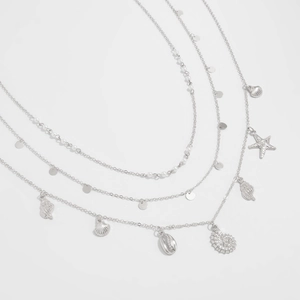 Detailed view of layered silver body chain with starfish, conch, and shell beach pendants