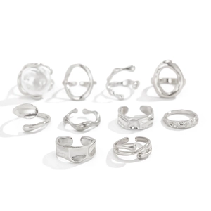 Macro view of 10-piece irregular silver rings set featuring white pearls and liquid metal texture