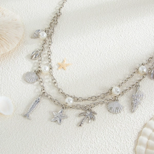 Detail of silver body chain with starfish, shell charms, and pearls for summer beach wear