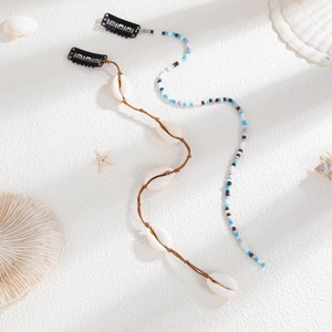 Close-up of Bohemian starfish shell hair clips on sand background for beach vacation styles