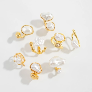 Detailed close-up of gold irregular metal rings with baroque pearls and zircon stones