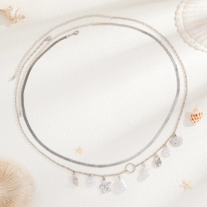 Silver double-layered body chain with starfish shell pendants and pearls on white background