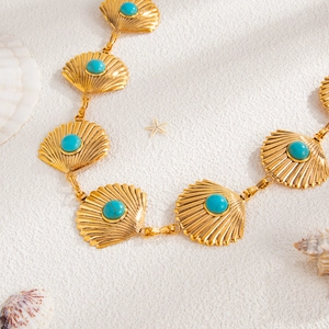 Detail of golden scallop shell links with turquoise beads on a summer beach body chain