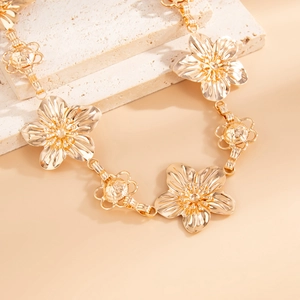 Macro detail of gold flower waist chain with radial textures and ornate metal petals